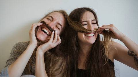 Two women laughing with each other. 